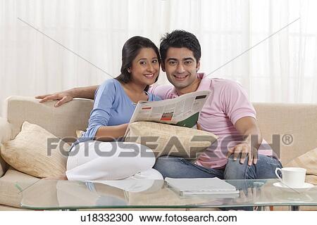 Portrait of young couple smiling with newspaper View Large Photo Image Stock Image - Portrait of young couple smiling with newspaper . Fotosearch