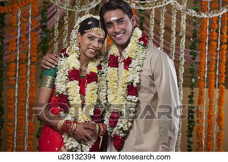 Portrait of young couple wearing garlands during traditional Indian wedding View Large Photo Image Picture - Portrait of young couple wearing garlands during traditional Indian wedding . Fotosearch