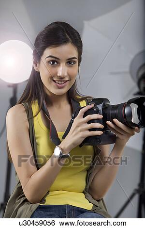 Portrait of young female photographer with digital camera sitting in studio View Large Photo Image Stock Photograph - Portrait of young female photographer with digital camera sitting in studio . Fotosearch