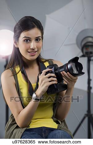 Portrait of young female photographer with camera sitting in studio View Large Photo Image Stock Photography - Portrait of young female photographer with camera sitting in studio . Fotosearch