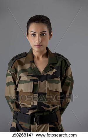 Portrait of young female soldier standing against colored background View Large Photo Image Stock Photo - Portrait of young female soldier standing against colored background . Fotosearch