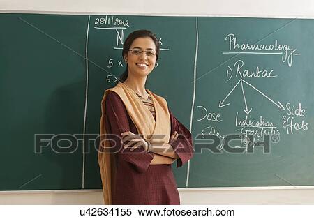 Portrait of young female teacher in traditional clothing standing with arms crossed against chalkboard View Large Photo Image Stock Photography - Portrait of young female teacher in traditional clothing standing with arms crossed against chalkboard . Fotosearch