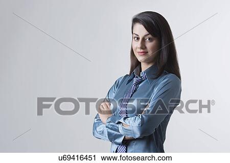 Portrait of young Indian businesswoman with arms crossed standing against gray background View Large Photo Image Stock Image - Portrait of young Indian businesswoman with arms crossed standing against gray background. Fotosearch