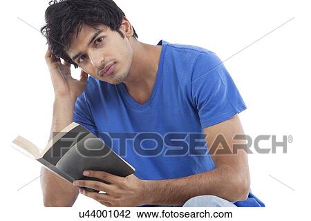 Portrait of young man holding book over white background View Large Photo Image Stock Image - Portrait of young man holding book over white background . Fotosearch