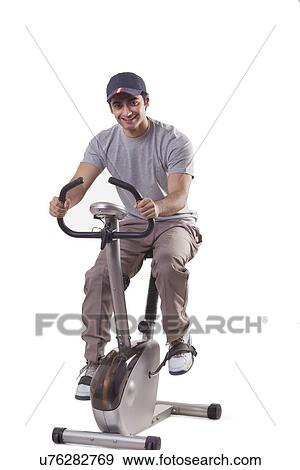 Portrait of young man on exercise bike View Large Photo Image Stock Photo - Portrait of young man on exercise bike . Fotosearch