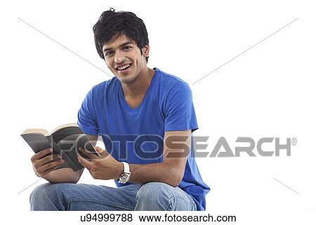 Stock Photo - Portrait of young man with book against white background . Fotosearch