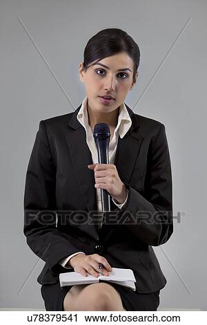 Portrait of young news reporter holding microphone with notepad View Large Photo Image Stock Image - Portrait of young news reporter holding microphone with notepad . Fotosearch