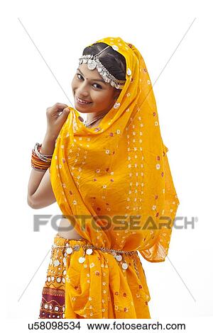 Portrait of young woman in chaniya choli looking over shoulder against white background View Large Photo Image Picture - Portrait of young woman in chaniya choli looking over shoulder against white background. Fotosearch