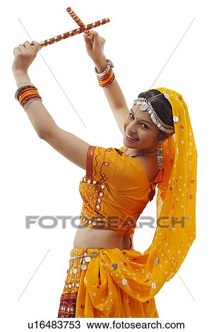 Portrait of young woman in chaniya choli performing Dandiya Raas over white background View Large Photo Image Stock Image - Portrait of young woman in chaniya choli performing Dandiya Raas over white background. Fotosearch