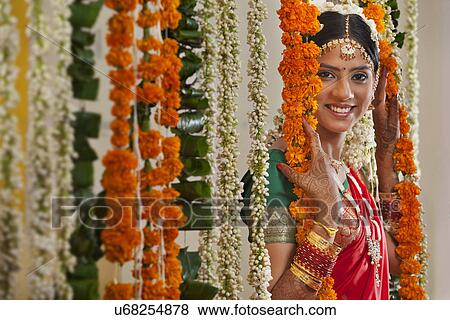 Portrait of young woman in traditional wear standing near garlands View Large Photo Image Stock Photo - Portrait of young woman in traditional wear standing near garlands . Fotosearch