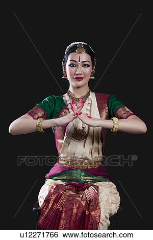 Stock Photograph - Portrait of young woman making Bharatanatyam gesture called Karkatam on black background. Fotosearch