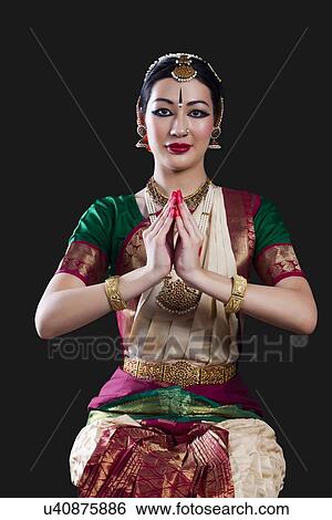 Stock Photograph - Portrait of young woman making Bharatanatyam gesture called Kapotam on black background. Fotosearch