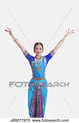Stock Image - Portrait of young woman performing Bharatanatyam over white background. Fotosearch
