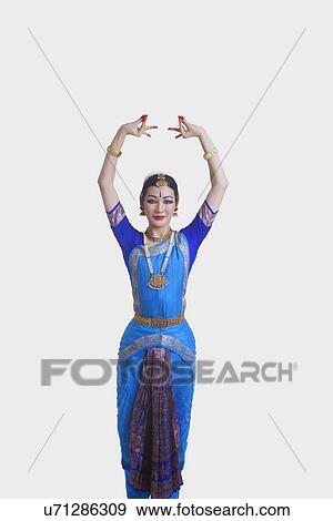 Stock Photo - Portrait of young woman performing Bharatanatyam over white background. Fotosearch