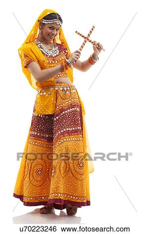 Portrait of young woman performing Dandiya Raas isolated over white background View Large Photo Image Stock Photograph - Portrait of young woman performing Dandiya Raas isolated over white background. Fotosearch