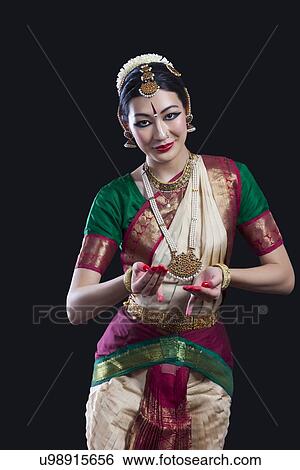 Portrait of young woman performing Indian classical dance over black background View Large Photo Image Stock Photograph - Portrait of young woman performing Indian classical dance over black background. Fotosearch