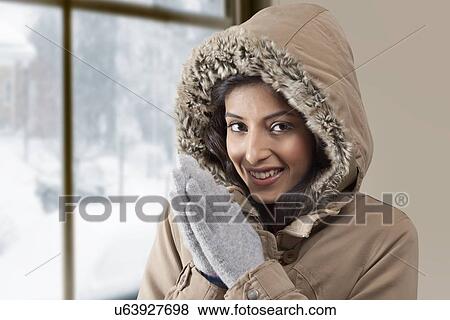 Stock Photo - Portrait of young woman rubbing hands . Fotosearch