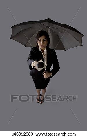 Portrait of young woman with umbrella asking comment View Large Photo Image Stock Image - Portrait of young woman with umbrella asking comment . Fotosearch
