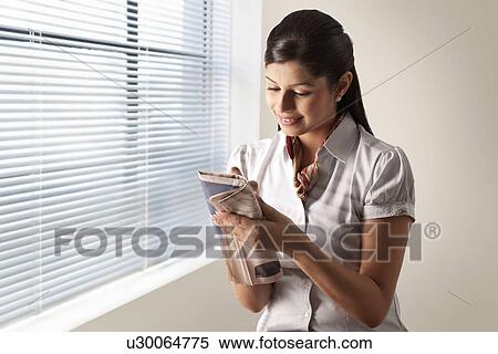 Pretty businesswoman solving puzzle on newspaper View Large Photo Image Stock Photography - Pretty businesswoman solving puzzle on newspaper . Fotosearch