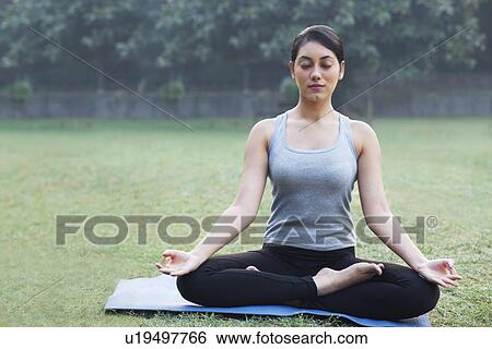 Pretty young woman meditating in park View Large Photo Image Stock Photograph - Pretty young woman meditating in park . Fotosearch