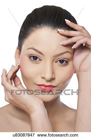 Stock Photo - Pretty young woman touching her face . Fotosearch
