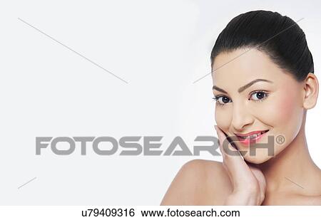 Stock Photograph - Pretty young woman touching her face . Fotosearch