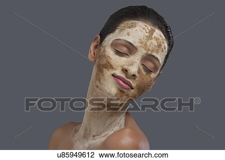 Pretty young woman with face pack over colored background View Large Photo Image Stock Image - Pretty young woman with face pack over colored background . Fotosearch