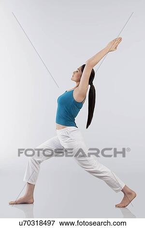 Stock Photo - Profile shot of young woman doing back bend yoga pose on wooden floor. Fotosearch