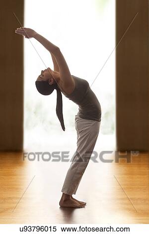 Profile shot of young woman doing back bend yoga pose on wooden floor View Large Photo Image Stock Photography - Profile shot of young woman doing back bend yoga pose on wooden floor. Fotosearch