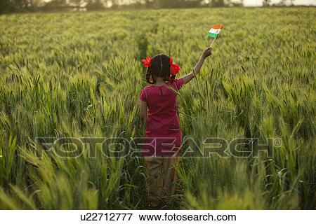 Stock Photo - Rear view of little girl holding an Indian flag . Fotosearch