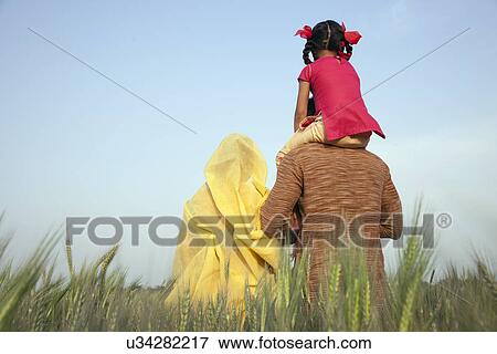Stock Photo - Rear view of rural family in the field . Fotosearch