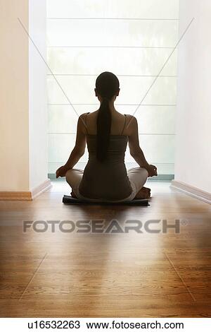 Rear view of young woman meditating on hardwood floor View Large Photo Image Stock Image - Rear view of young woman meditating on hardwood floor. Fotosearch