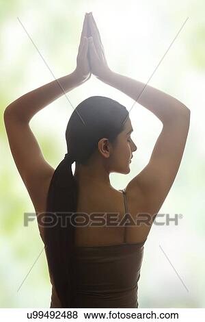 Rear view of young woman meditating View Large Photo Image Stock Photo - Rear view of young woman meditating. Fotosearch