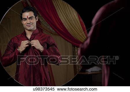 Reflection of young bridegroom getting dressed View Large Photo Image Stock Photography - Reflection of young bridegroom getting dressed . Fotosearch