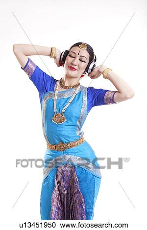 Relaxed Bharatanatyam dancer listening music on headphones over white background View Large Photo Image Stock Image - Relaxed Bharatanatyam dancer listening music on headphones over white background. Fotosearch