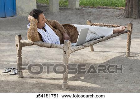 Relaxed rural man using laptop View Large Photo Image Stock Image - Relaxed rural man using laptop . Fotosearch