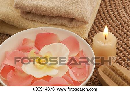 Stock Image - Rose petals and orchid in a bowl with nail brush . Fotosearch