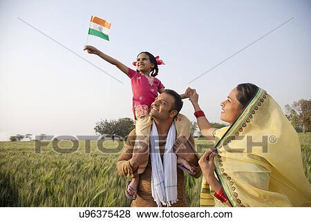 Stock Photo - Rural family in the field with girl holding Indian flag . Fotosearch