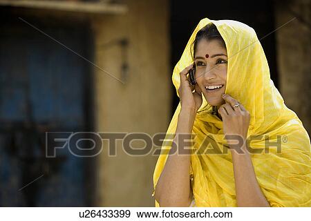 Rural woman talking on a mobile View Large Photo Image Stock Photo - Rural woman talking on a mobile . Fotosearch