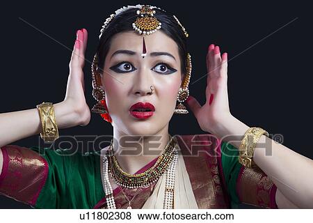 Stock Photo - Scared woman performing Bharatanatyam over black background. Fotosearch