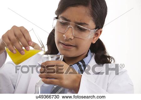 Stock Image - School girl mixing chemicals . Fotosearch