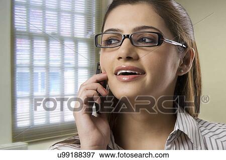 Secretary talking on a mobile phone View Large Photo Image Stock Photo - Secretary talking on a mobile phone . Fotosearch