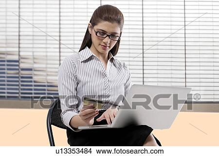 Secretary with a credit card and laptop View Large Photo Image Picture - Secretary with a credit card and laptop . Fotosearch