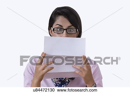Stock Image - Shocked businesswoman reading document over white background. Fotosearch
