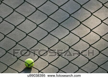 Shot of tennis ball lying on ground in front of net View Large Photo Image Stock Photography - Shot of tennis ball lying on ground in front of net . Fotosearch