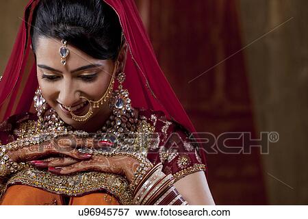 Stock Photo - Shy beautiful bride looking down and smiling . Fotosearch