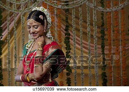 Shy Indian bride looking down and smiling View Large Photo Image Stock Photo - Shy Indian bride looking down and smiling . Fotosearch