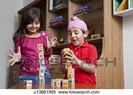 Siblings playing with wooden toy blocks View Large Photo Image Stock Photography - Siblings playing with wooden toy blocks . Fotosearch
