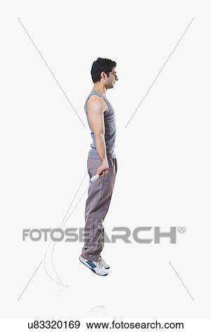 Side view of a young man skipping over white background View Large Photo Image Stock Photo - Side view of a young man skipping over white background . Fotosearch