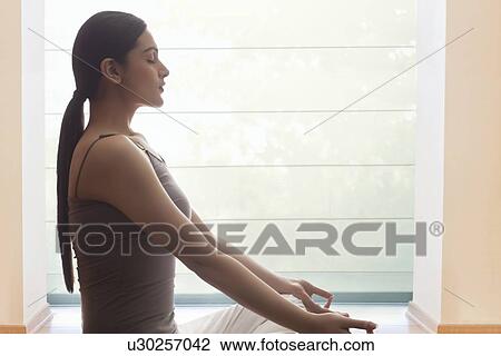 Side view of young woman meditating View Large Photo Image Stock Image - Side view of young woman meditating. Fotosearch